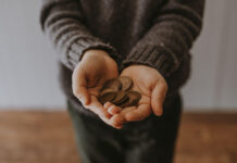 A woman holds coins in her hands, representing the investments Ari Stiegler makes